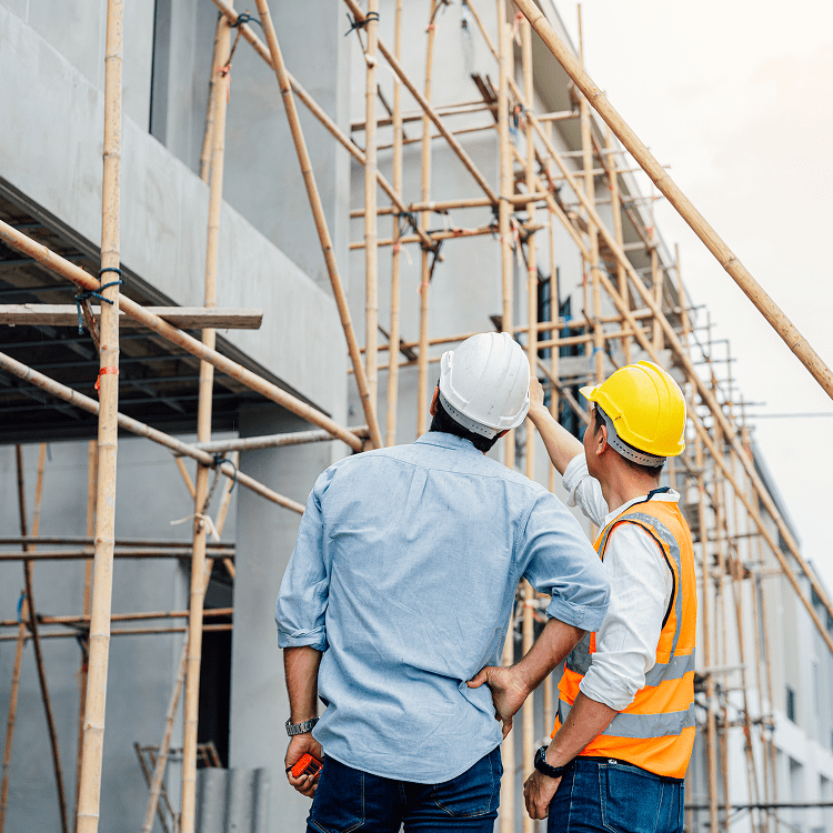 Construction workers inspecting scaffolding on site.